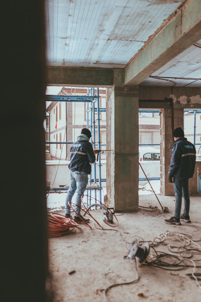 Construction workers in a partially built structure, showcasing teamwork.